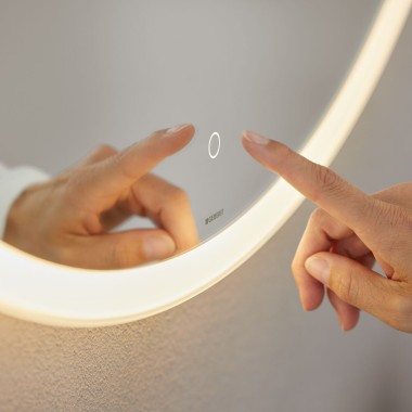 Interrupteur tactile à commande manuelle sur le miroir rond Geberit Option (© Geberit)