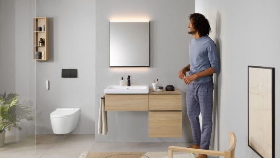 Un homme dans une salle de bains avec Geberit AquaClean Sela