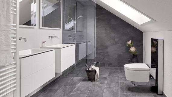 Salle de bains avec toit en pente et produits de la série Geberit ONE et Geberit AquaClean avec Monolith Salle de bains avec toit en pente et produits de la série Geberit ONE et Geberit AquaClean avec Monolith