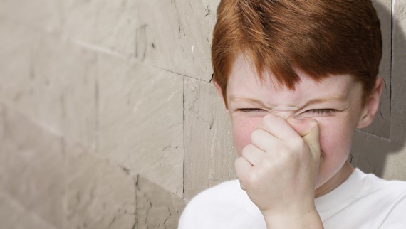 Un garçon qui se bouche le nez