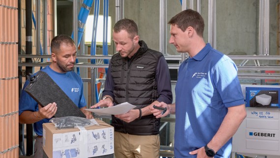 Un représentant de Geberit conseille les installateurs sanitaires sur le chantier.