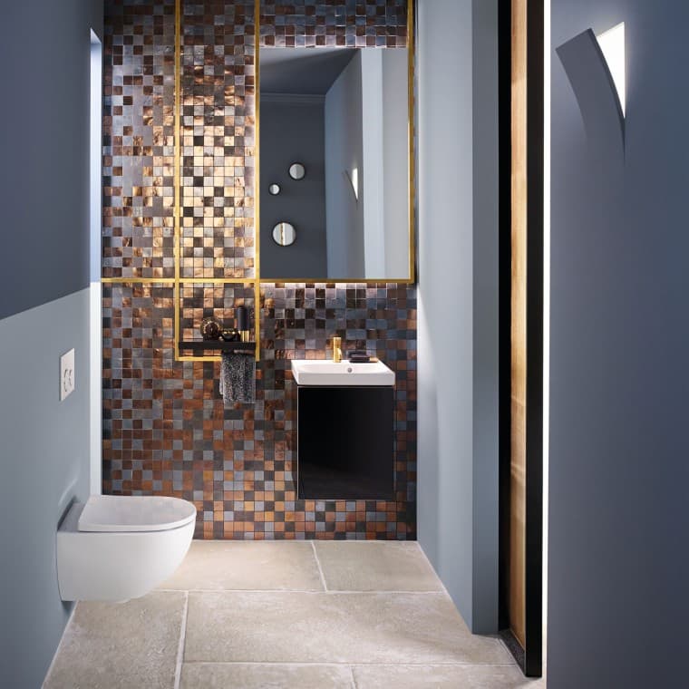 Vue d'une salle de bains moderne pour invités avec un WC Acanto et d'un lavabo Acanto devant un panneau arrière en mosaïque. Vue d'une salle de bains moderne pour invités avec un WC Acanto et d'un lavabo Acanto devant un panneau arrière en mosaïque.