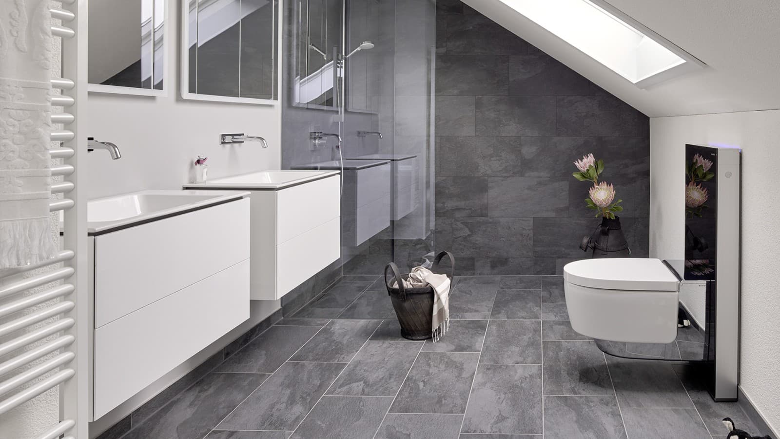 Salle de bains avec toit en pente et produits de la série Geberit ONE et Geberit AquaClean avec Monolith Salle de bains avec toit en pente et produits de la série Geberit ONE et Geberit AquaClean avec Monolith